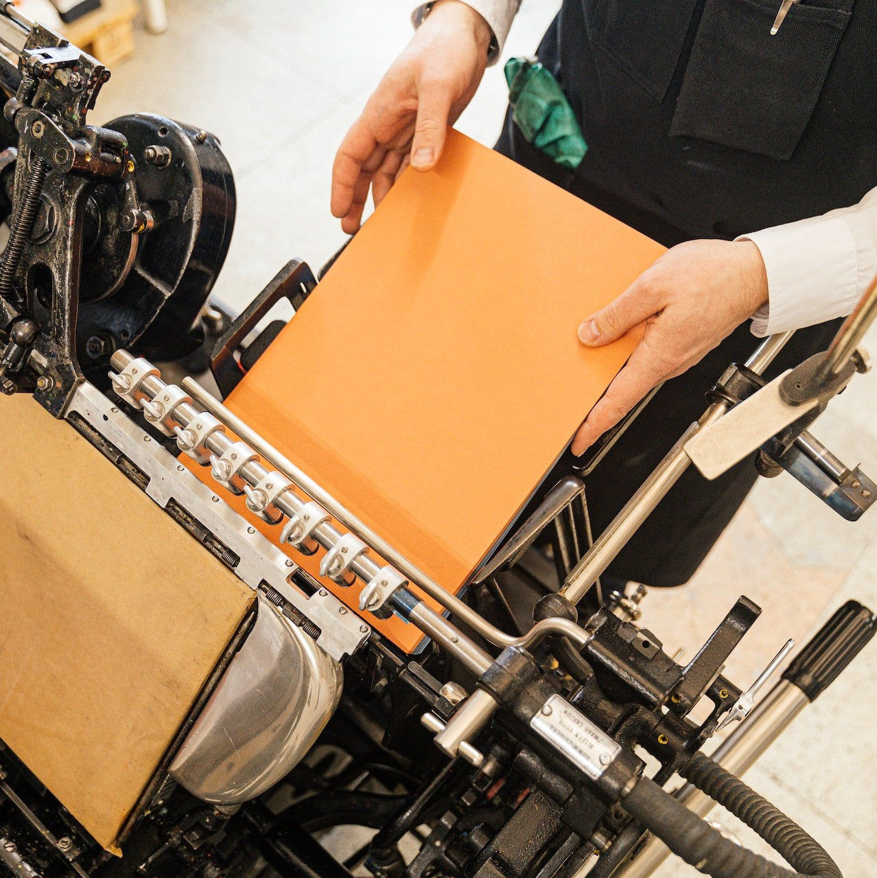 Ein Buchbinder betätigt seine Maschine