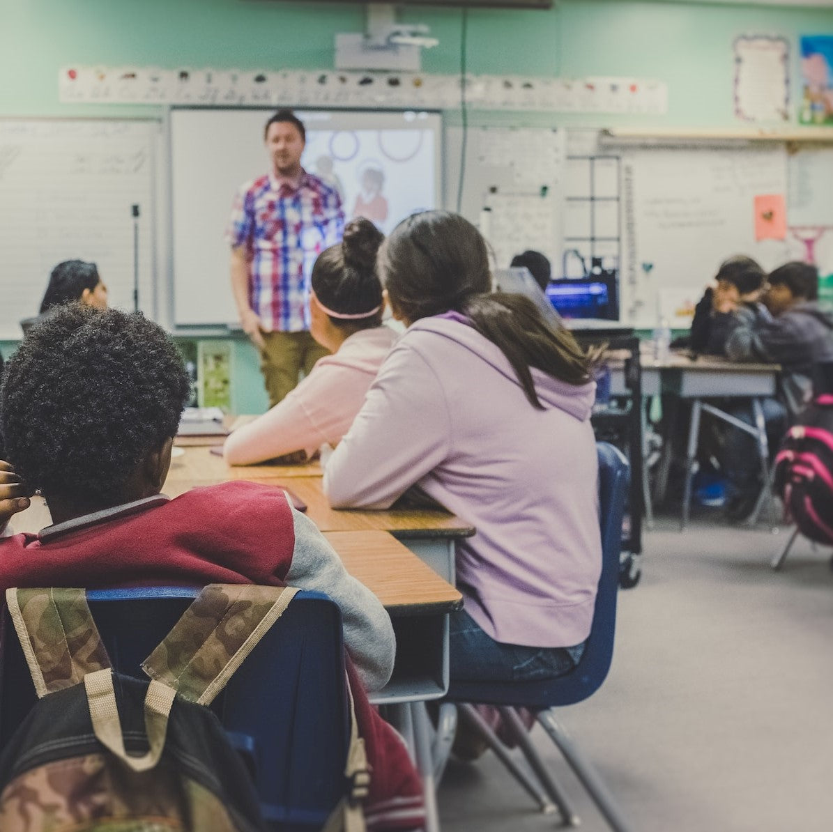Kinder blicken zum Lehrer in einer Schulklasse