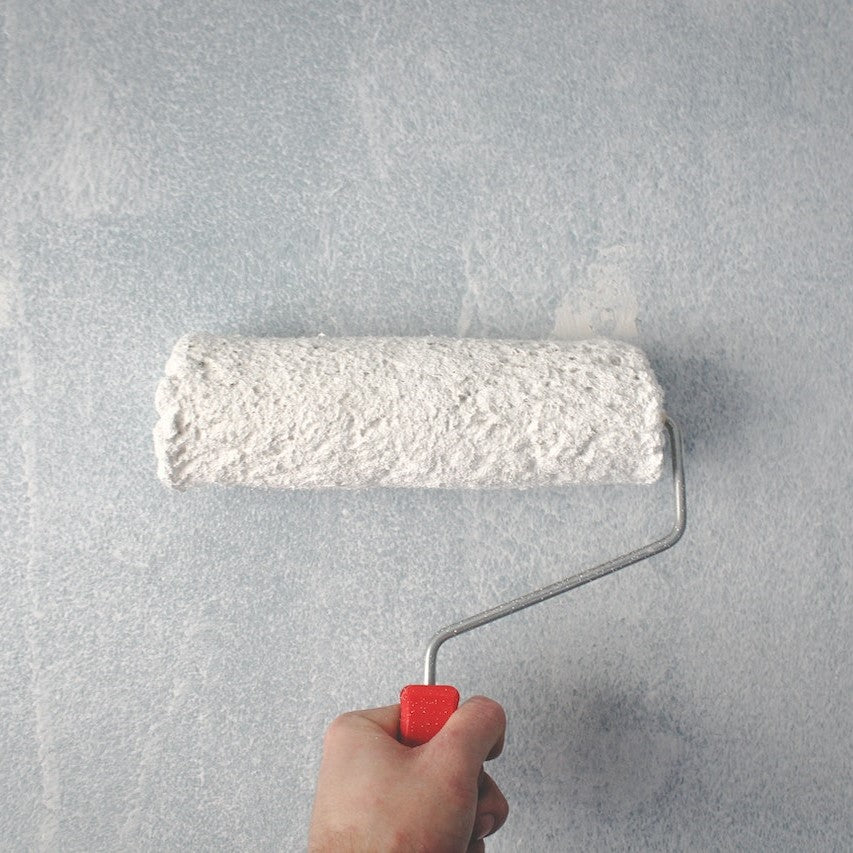 Ein Maler streicht eine Wand