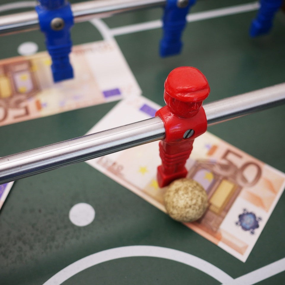 Tischkicker, auf dem zwei 50€-Scheine liegen