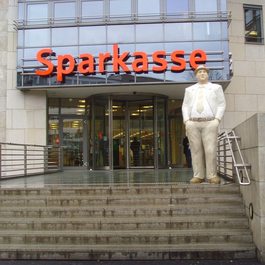 Blick auf eine Sparkassen-Filiale mit Statue im Eingangsbereich