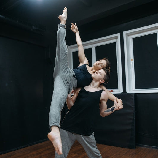 Ein Mann und eine Frau üben eine Ballett-Figur in einer Ballettschule