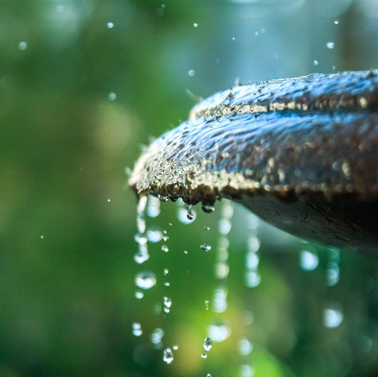 Wassertropfen an der Kante eines Brunnens