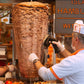 Ein Mann schneidet Dönerfleisch vom Dönerspieß