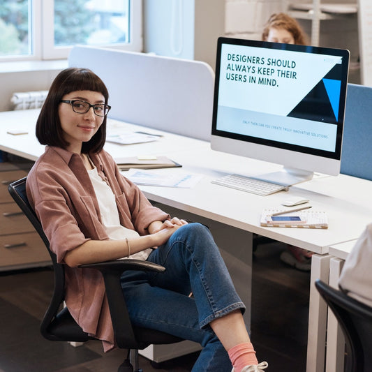 Eine Grafikdesignerin in einem Büro blickt lächelnd zur Seite