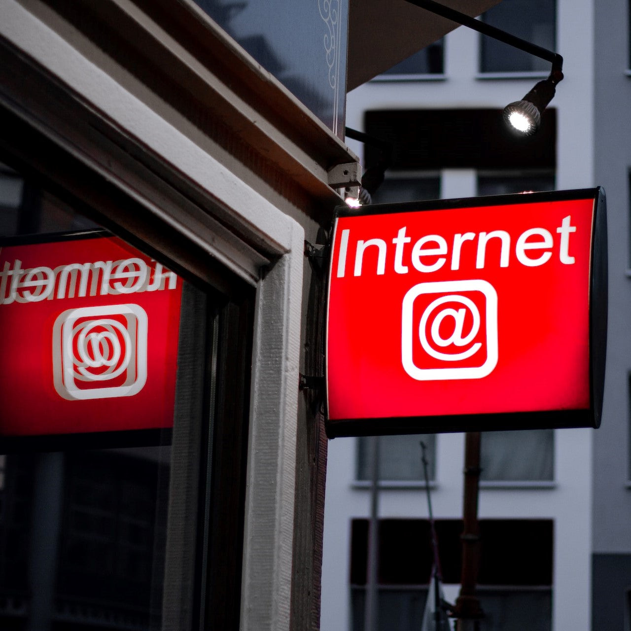 Ein rotes Schild mit der Aufschrift "Internet" hängt vor einem Internetcafé