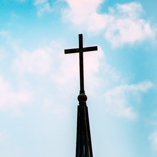 Kreuz auf der Spitze eines Kirchturms ragt in den Himmel
