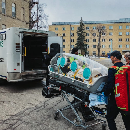 Rettungssanitäter transportieren einen Menschen in einen Krankentransporter