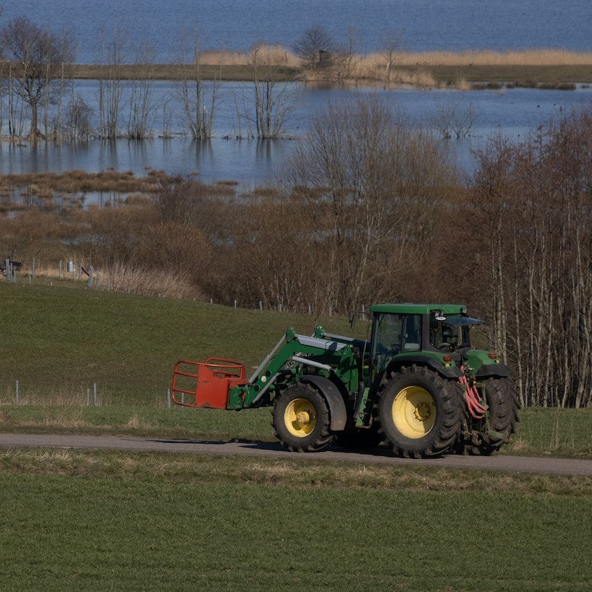 Bild eines Traktors, der einen Feldweg entlangfährt