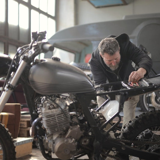 Ein Mechaniker untersucht ein Motorrad in einer Motorradwerkstatt