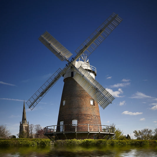 Eine Mühle steht hinter einem Fluss