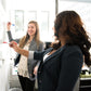 Zwei Frauen im Office schreiben an ein Whiteboard