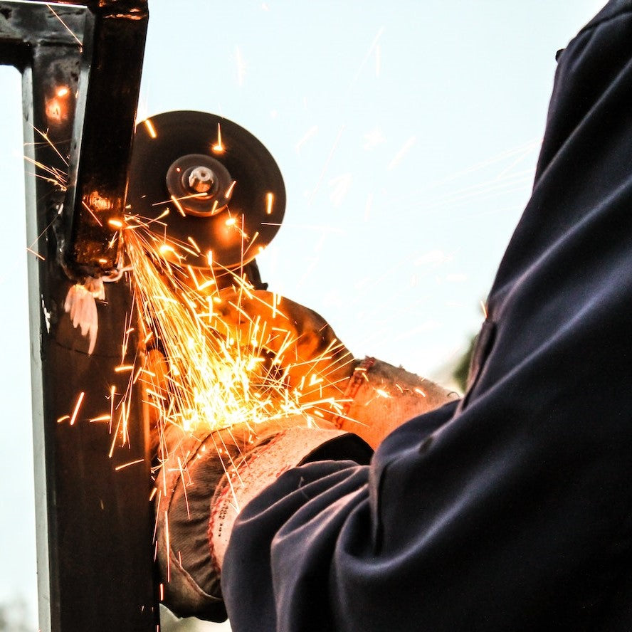 Ein Schleifer arbeitet mit einer Maschine, aus der Funken sprühen