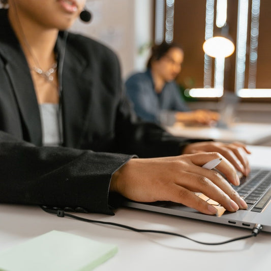 Eine Frau tippt im Büro auf einer Laptop-Tastatur