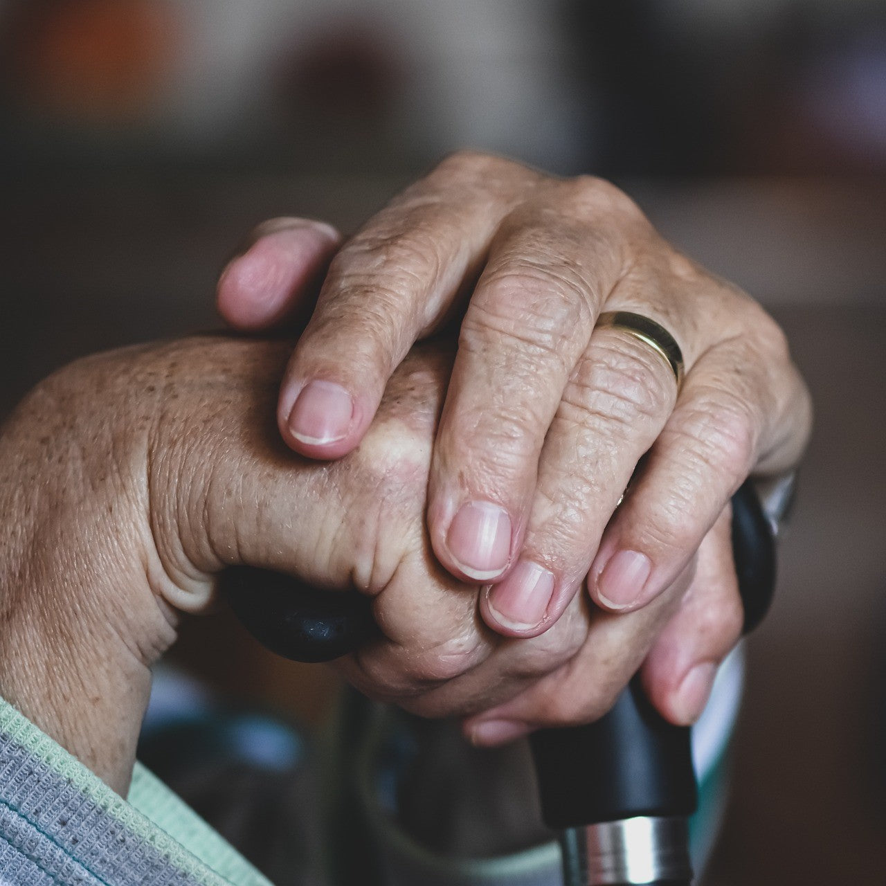 Eine Seniorin stützt sich auf einen Gehstock