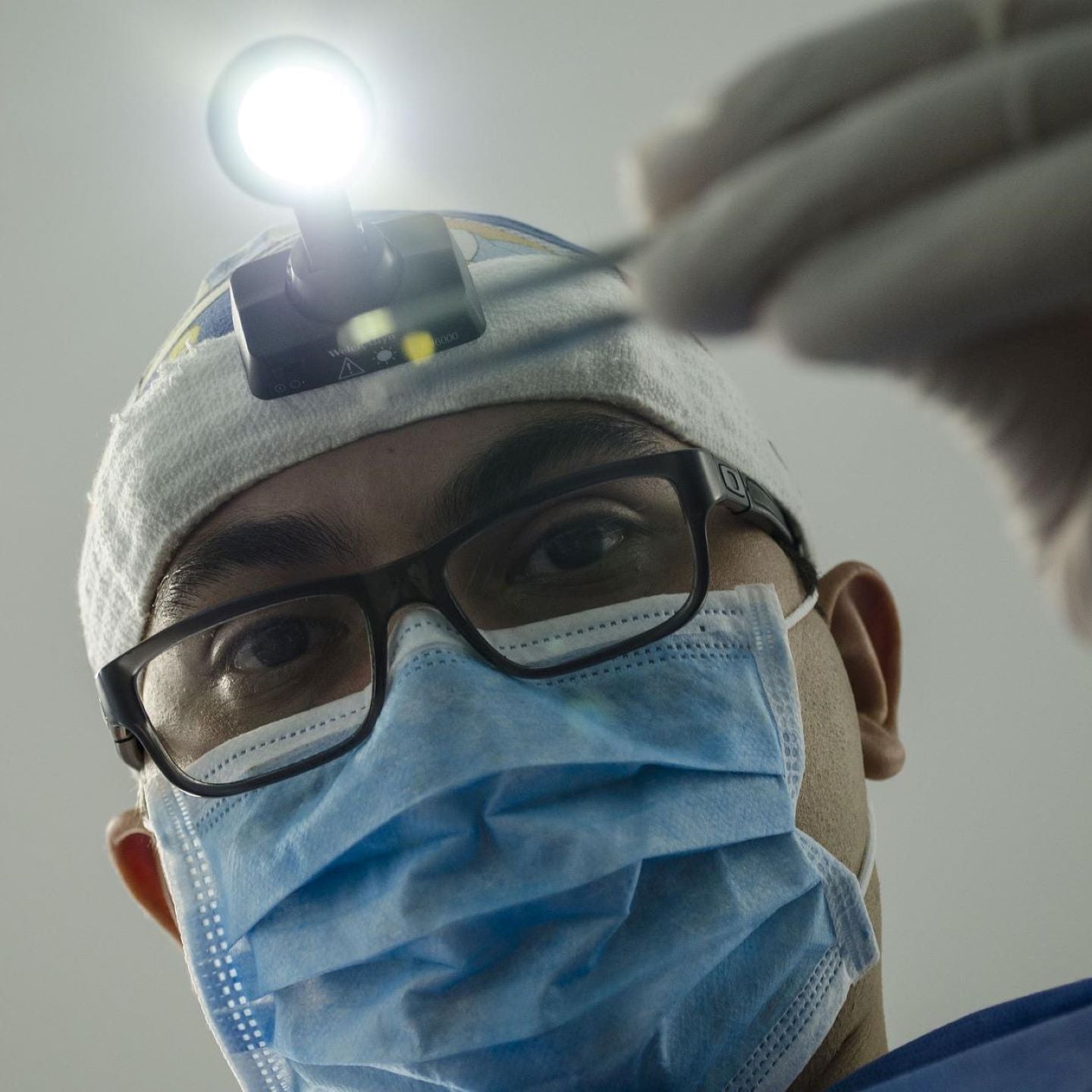 Zahnarzt beugt sich über Patienten